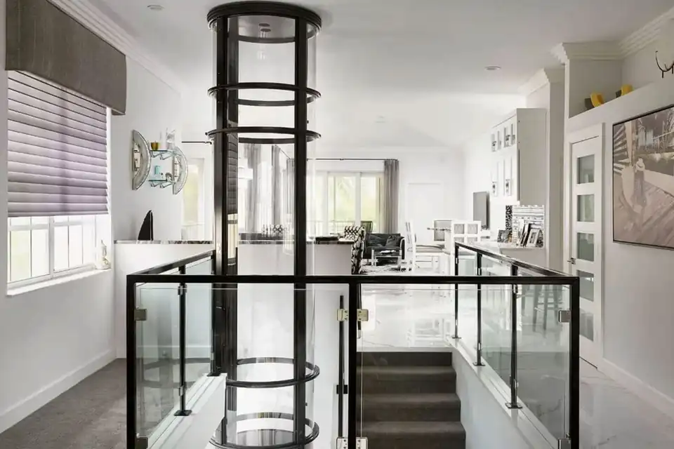 Elevador residencial panorâmico conectado ao pavimento superior com guarda-corpo de vidro
